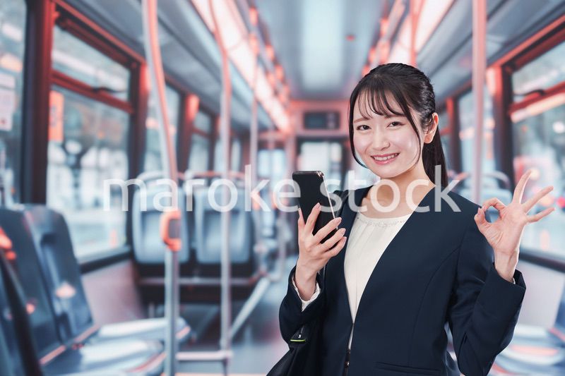 バスに乗って通勤をする若い女性