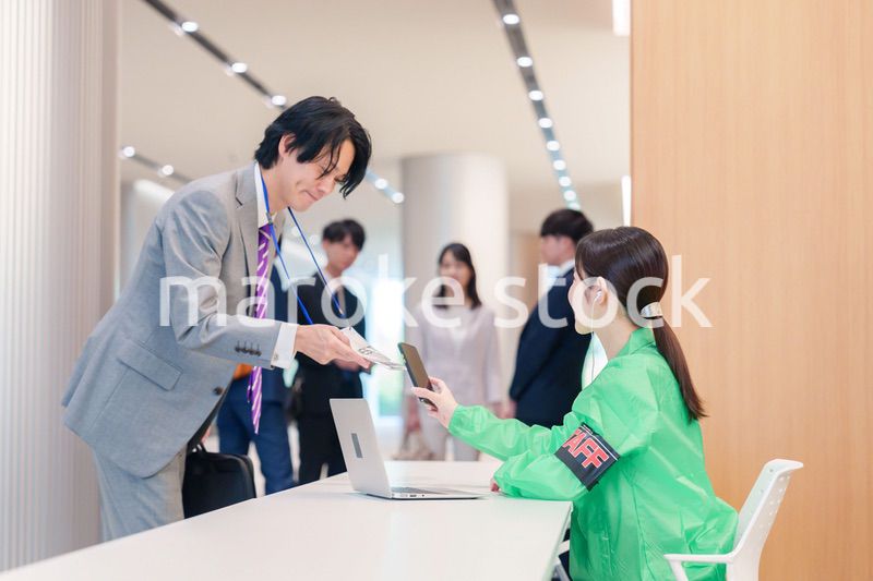 カンファレンスの受付スタッフと参加者