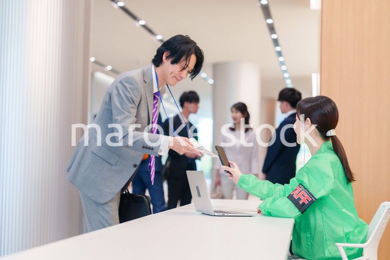 カンファレンスの受付スタッフと参加者