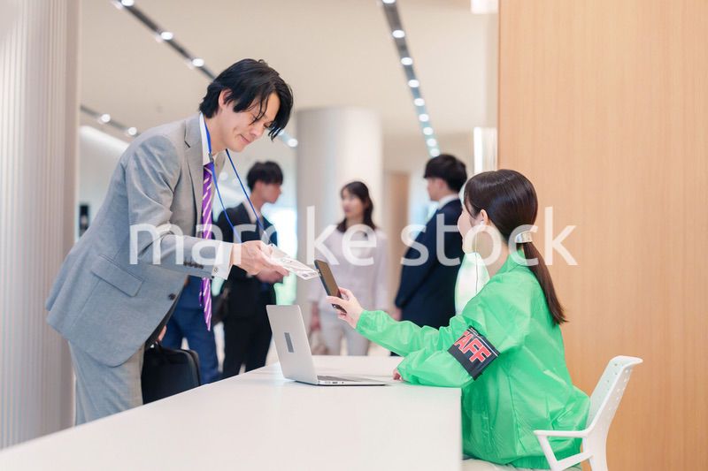 カンファレンスの受付スタッフと参加者