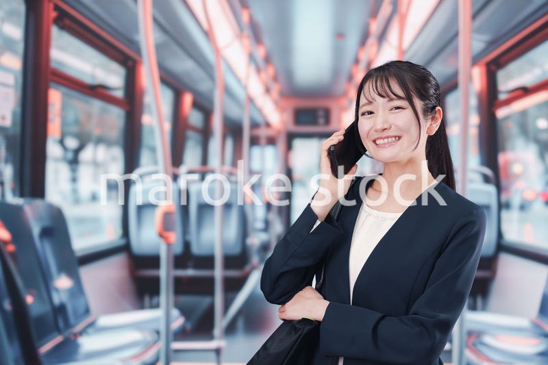 バスに乗って通勤をする若い女性