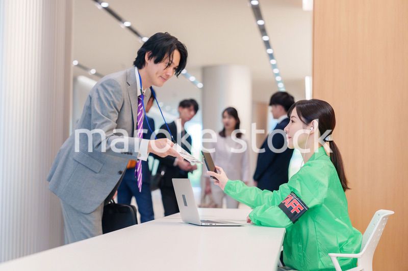 カンファレンスの受付スタッフと参加者