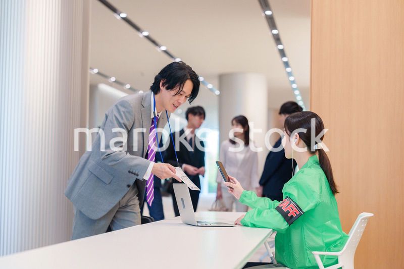 カンファレンスの受付スタッフと参加者