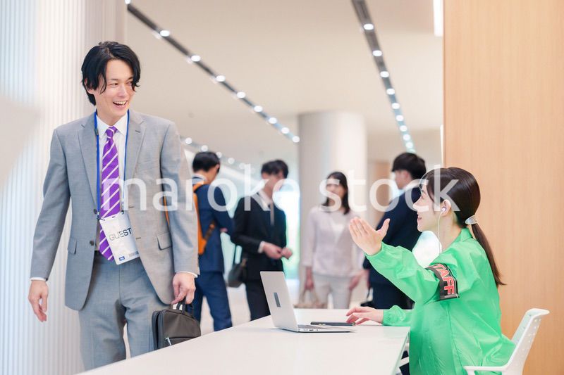 カンファレンスの受付スタッフと参加者