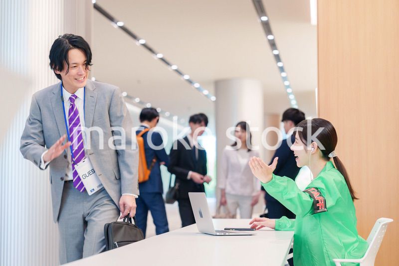 カンファレンスの受付スタッフと参加者