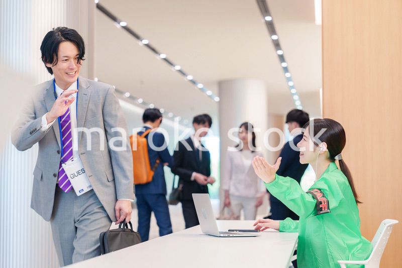 カンファレンスの受付スタッフと参加者