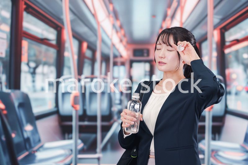 バスに乗って通勤をする若い女性