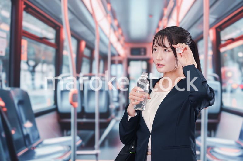 バスに乗って通勤をする若い女性