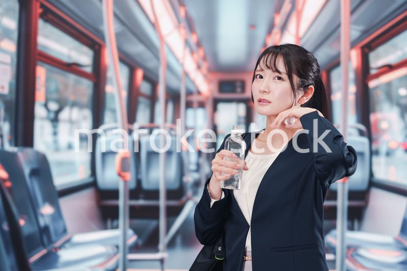 バスに乗って通勤をする若い女性