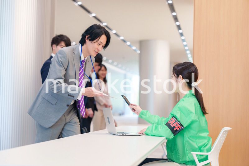 カンファレンスの受付スタッフと参加者