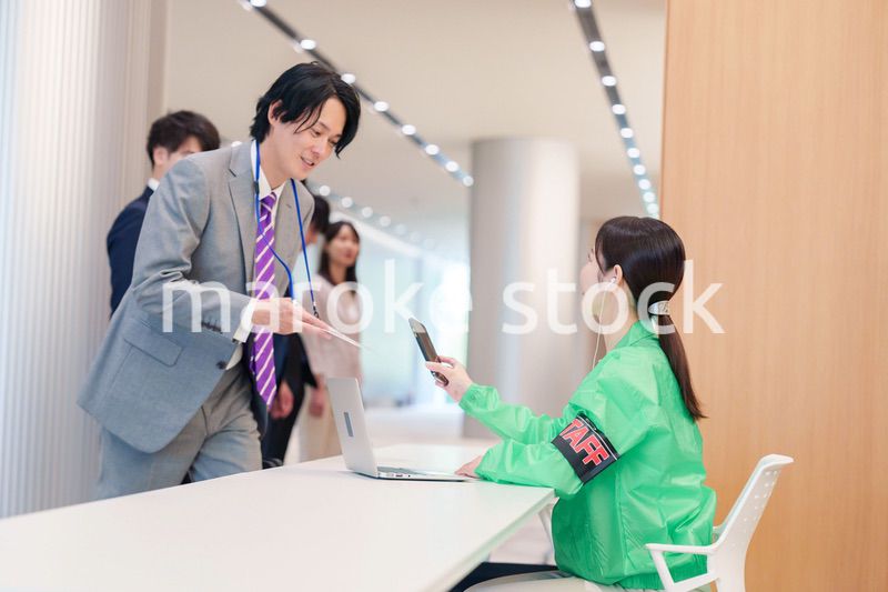 カンファレンスの受付スタッフと参加者