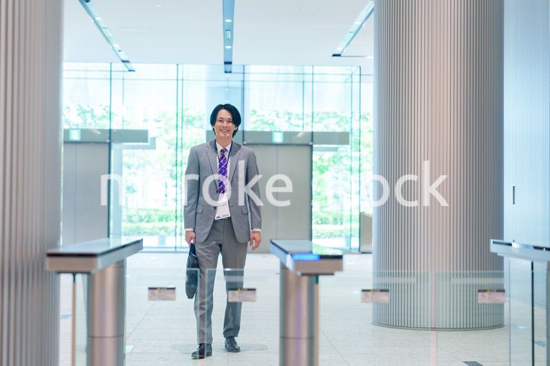 ゲストバッジをつけてビルに入館するビジネスマン