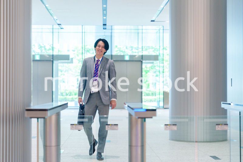 ゲストバッジをつけてビルに入館するビジネスマン