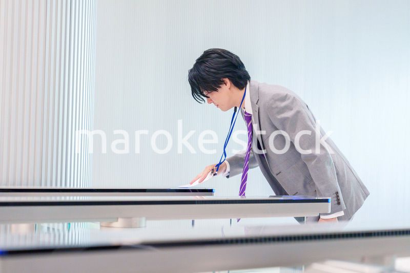 ゲストバッジをつけてビルに入館するビジネスマン