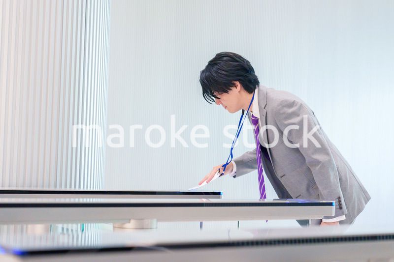 ゲストバッジをつけてビルに入館するビジネスマン