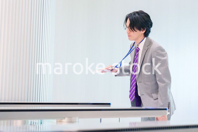 ゲストバッジをつけてビルに入館するビジネスマン