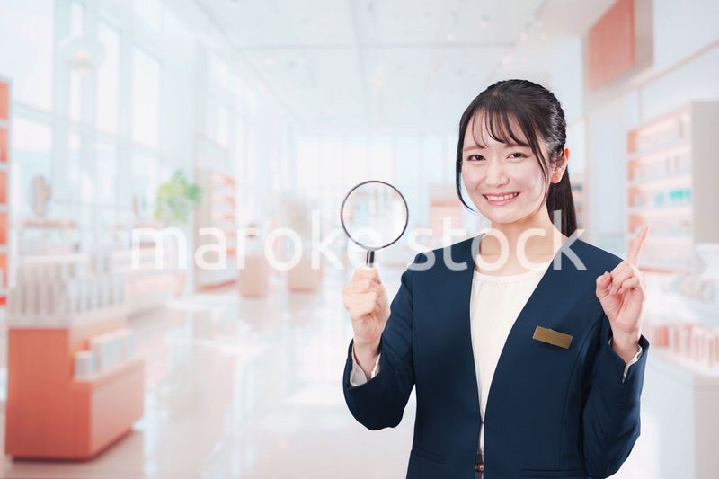 笑顔でルーペを持つ美容部員の女性