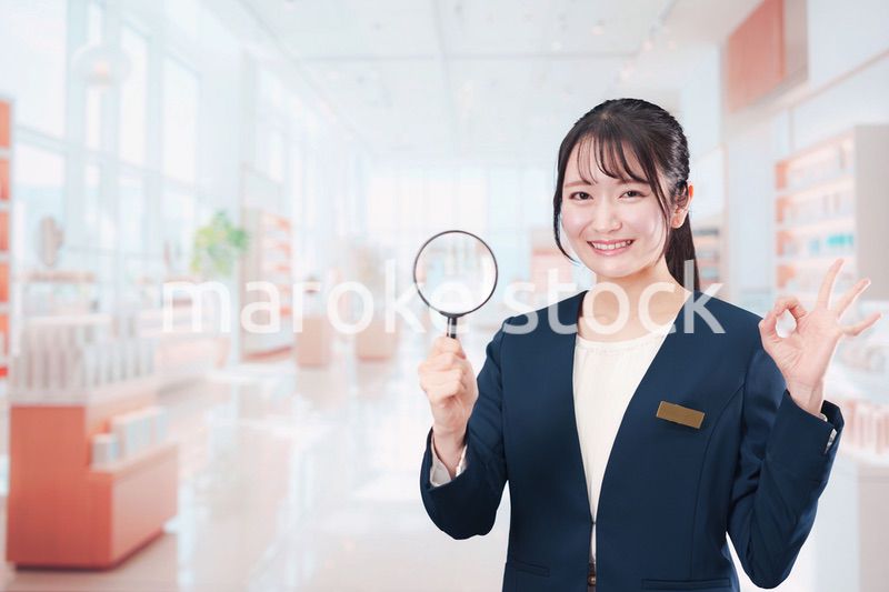 笑顔でルーペを持つ美容部員の女性