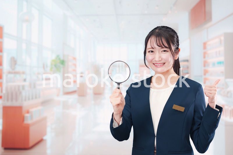 笑顔でルーペを持つ美容部員の女性