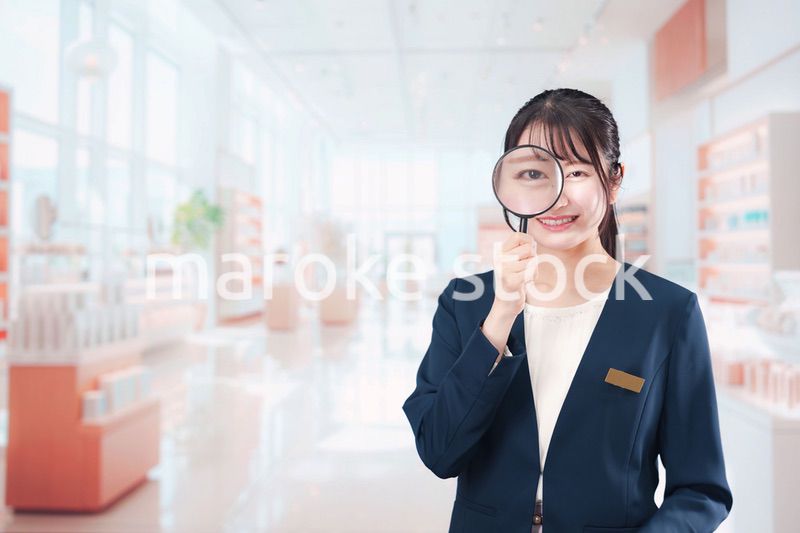 笑顔でルーペを持つ美容部員の女性