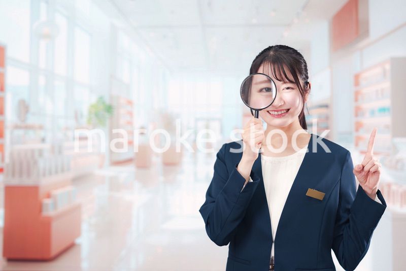 笑顔でルーペを持つ美容部員の女性