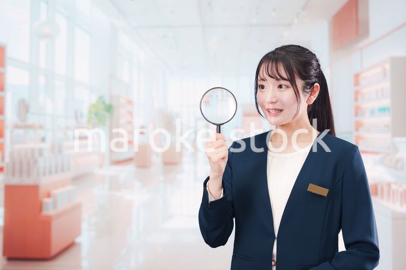 笑顔でルーペを持つ美容部員の女性