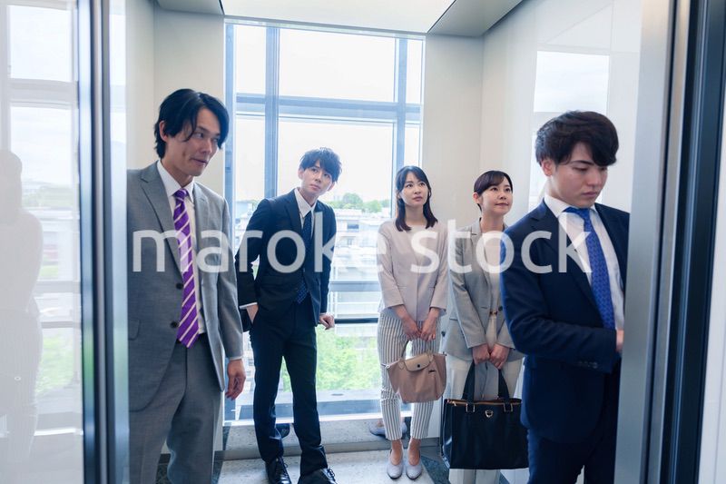 オフィスでエレベーターに乗るビジネスパーソン