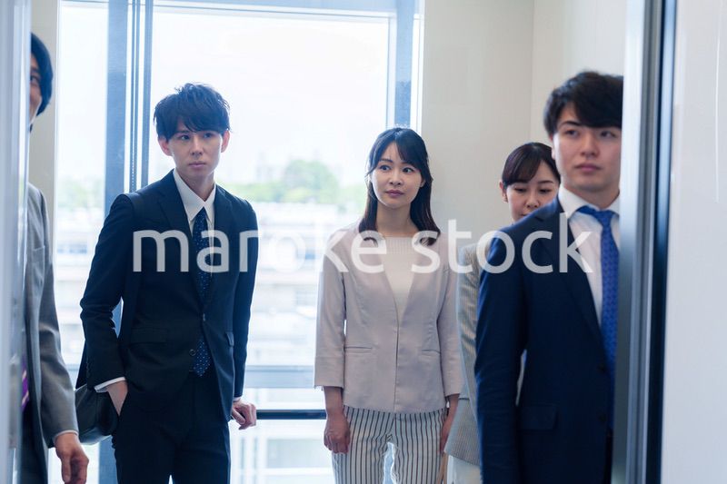 オフィスでエレベーターに乗るビジネスパーソン