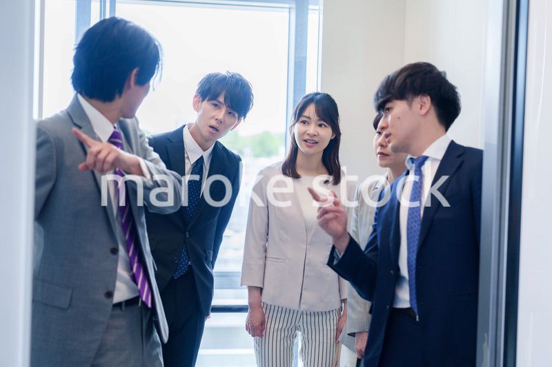 オフィスでエレベーターに乗るビジネスパーソン