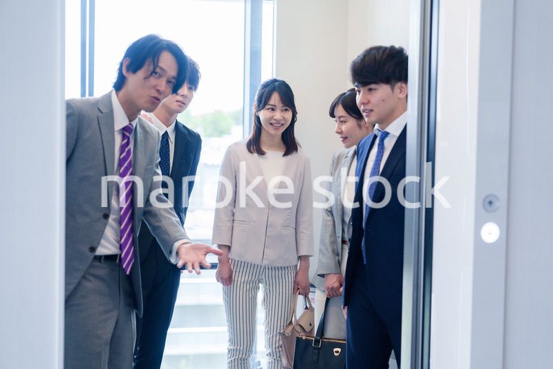 オフィスでエレベーターに乗るビジネスパーソン