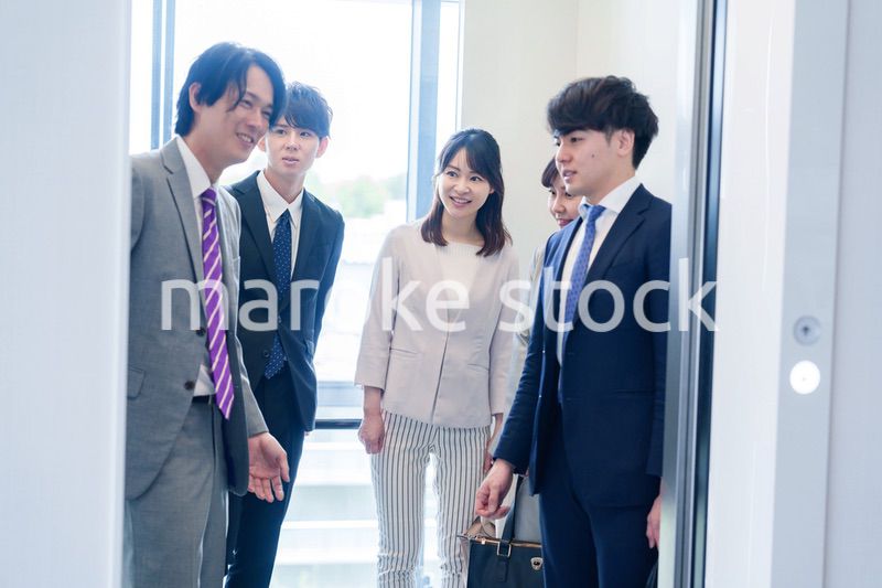 オフィスでエレベーターに乗るビジネスパーソン
