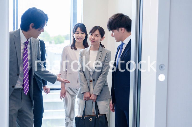 オフィスでエレベーターに乗るビジネスパーソン