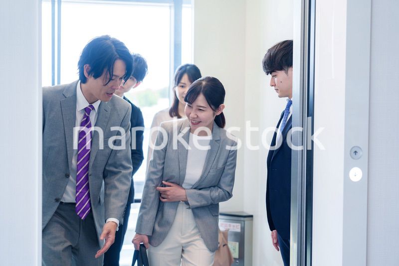 オフィスでエレベーターに乗るビジネスパーソン