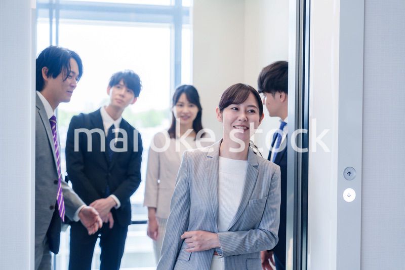 オフィスでエレベーターに乗るビジネスパーソン
