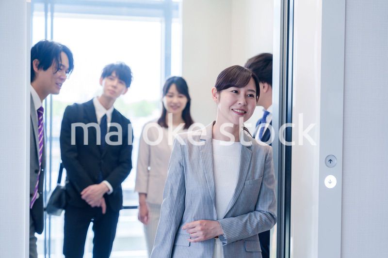 オフィスでエレベーターに乗るビジネスパーソン