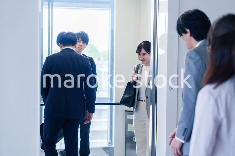 オフィスでエレベーターに乗るビジネスパーソン
