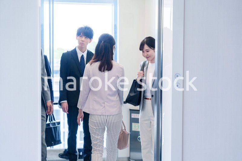 オフィスでエレベーターに乗るビジネスパーソン