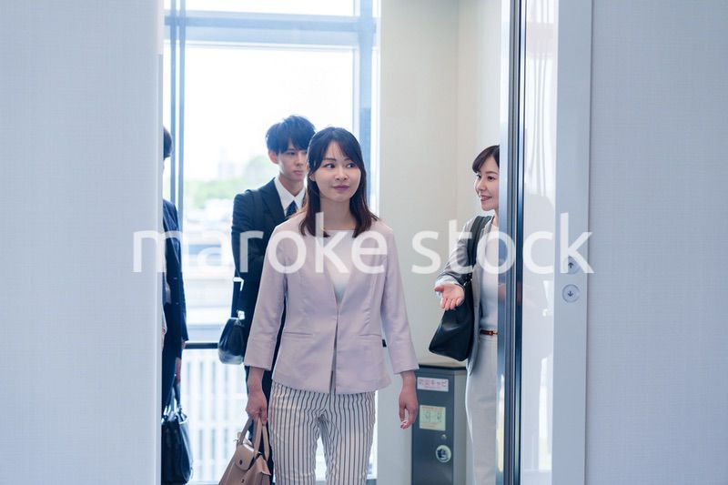 オフィスでエレベーターに乗るビジネスパーソン