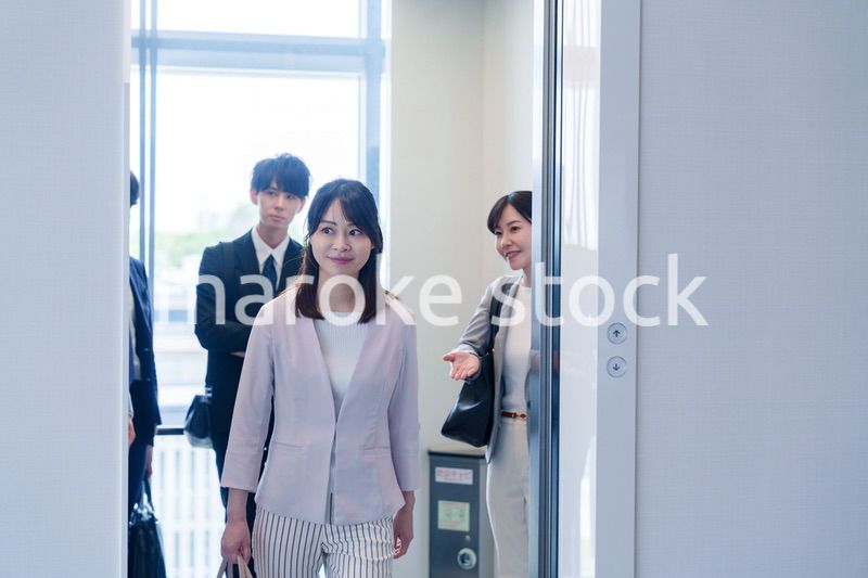 オフィスでエレベーターに乗るビジネスパーソン