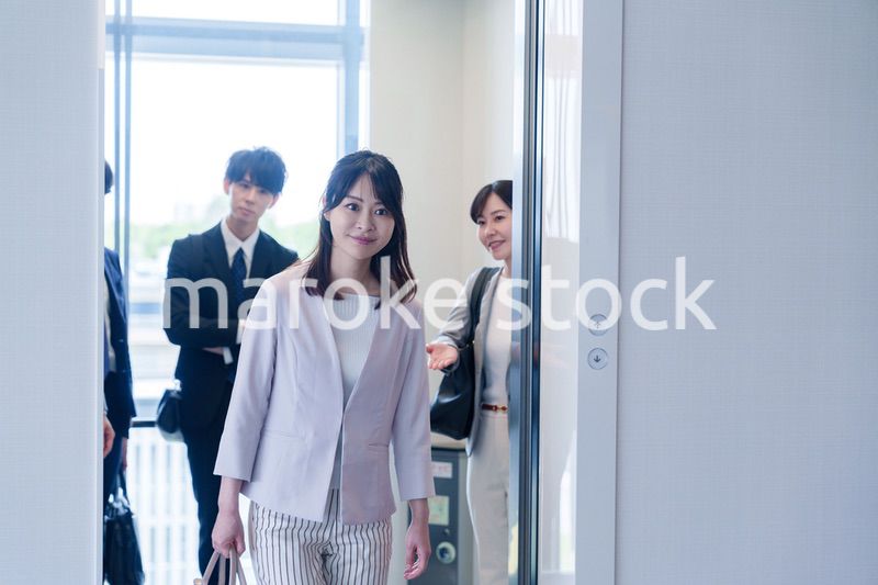 オフィスでエレベーターに乗るビジネスパーソン