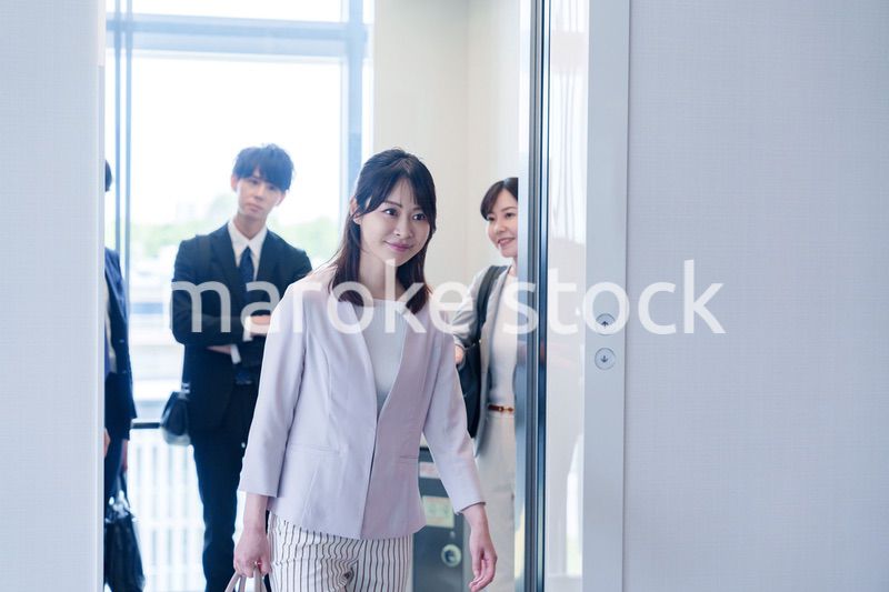 オフィスでエレベーターに乗るビジネスパーソン