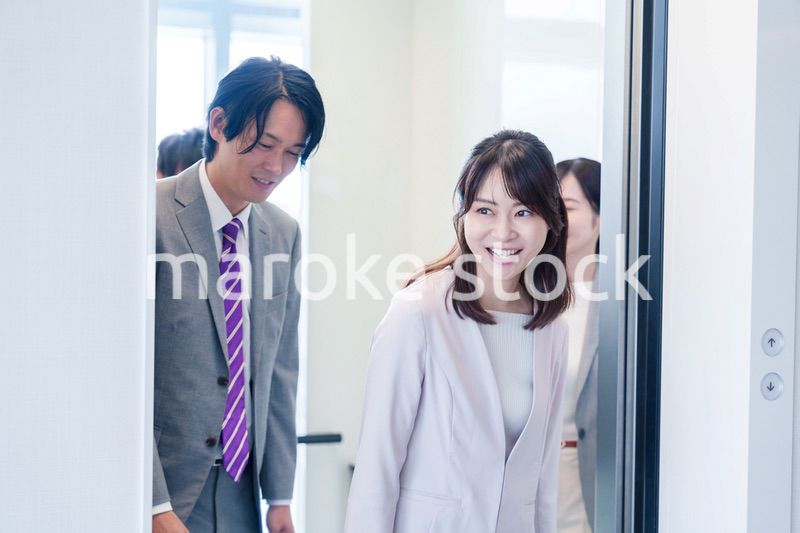 オフィスでエレベーターに乗るビジネスパーソン
