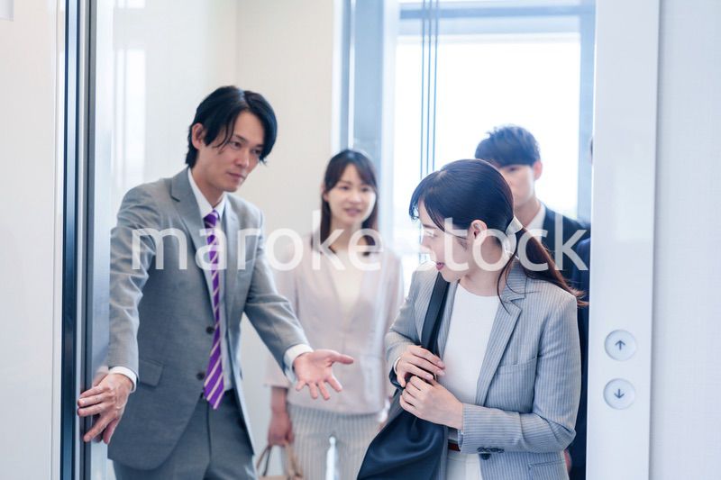 オフィスでエレベーターに乗るビジネスパーソン