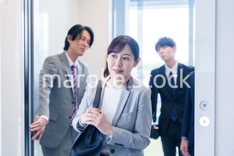 オフィスでエレベーターに乗るビジネスパーソン