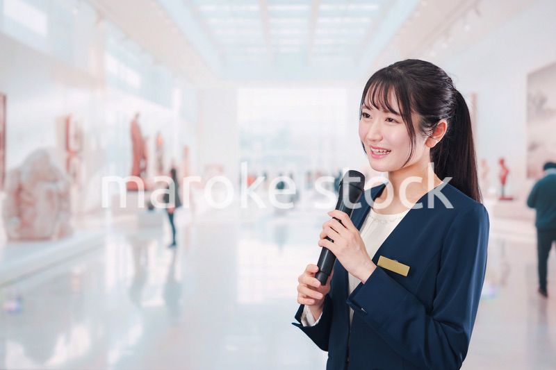 博物館で司会をする学芸員の女性