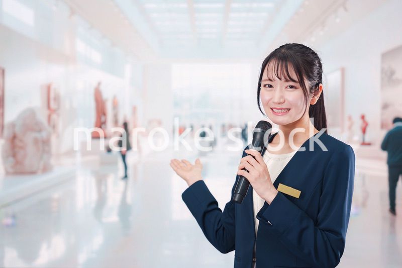 博物館で司会をする学芸員の女性
