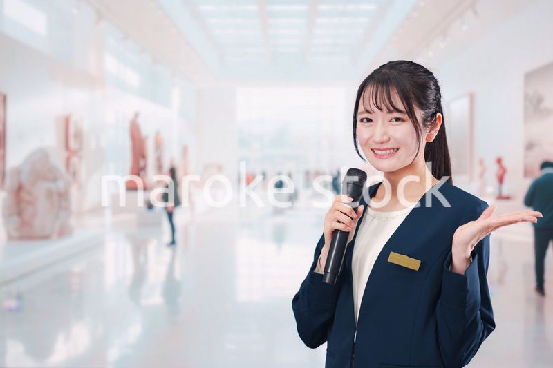 博物館で司会をする学芸員の女性
