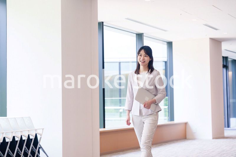 オフィスの中で笑顔で歩くビジネスウーマン