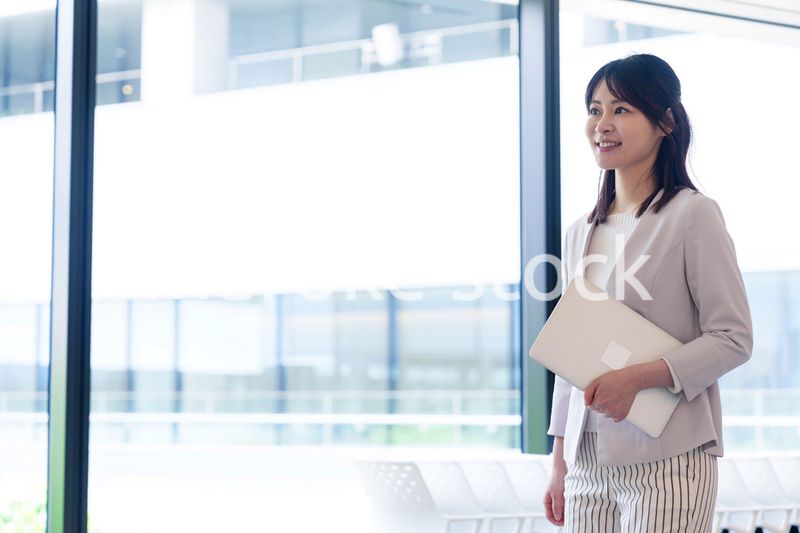 オフィスの中で笑顔で歩くビジネスウーマン