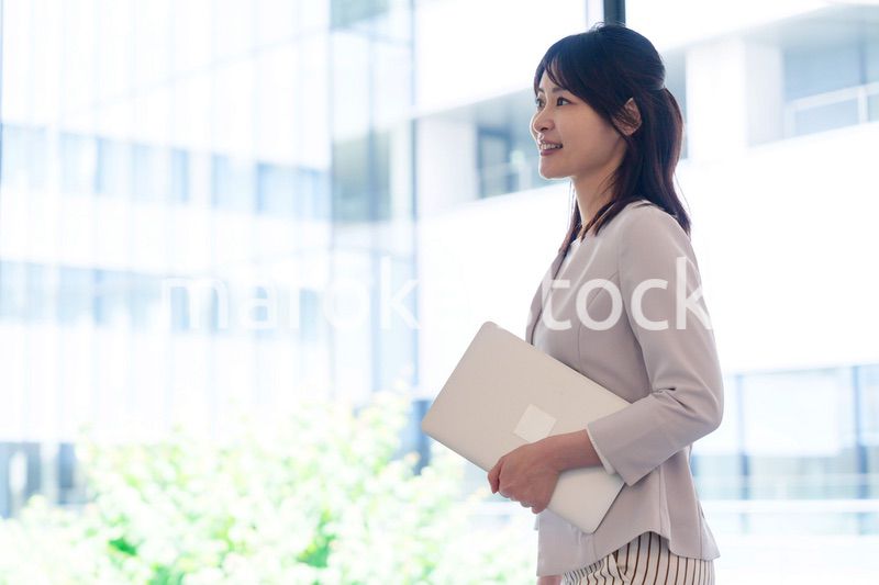 オフィスの中で笑顔で歩くビジネスウーマン